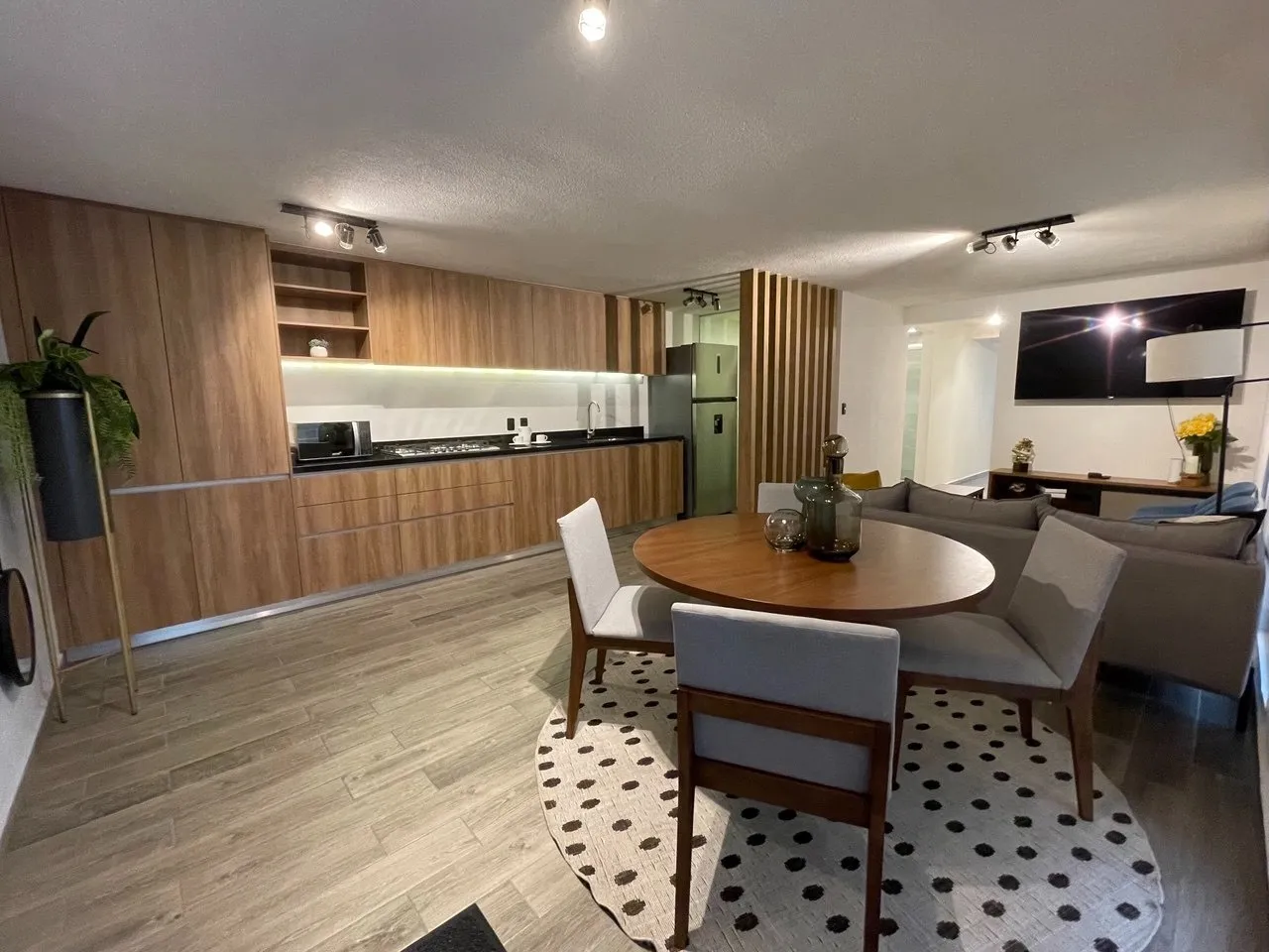Cocina integral con comedor redondo y sala al fondo