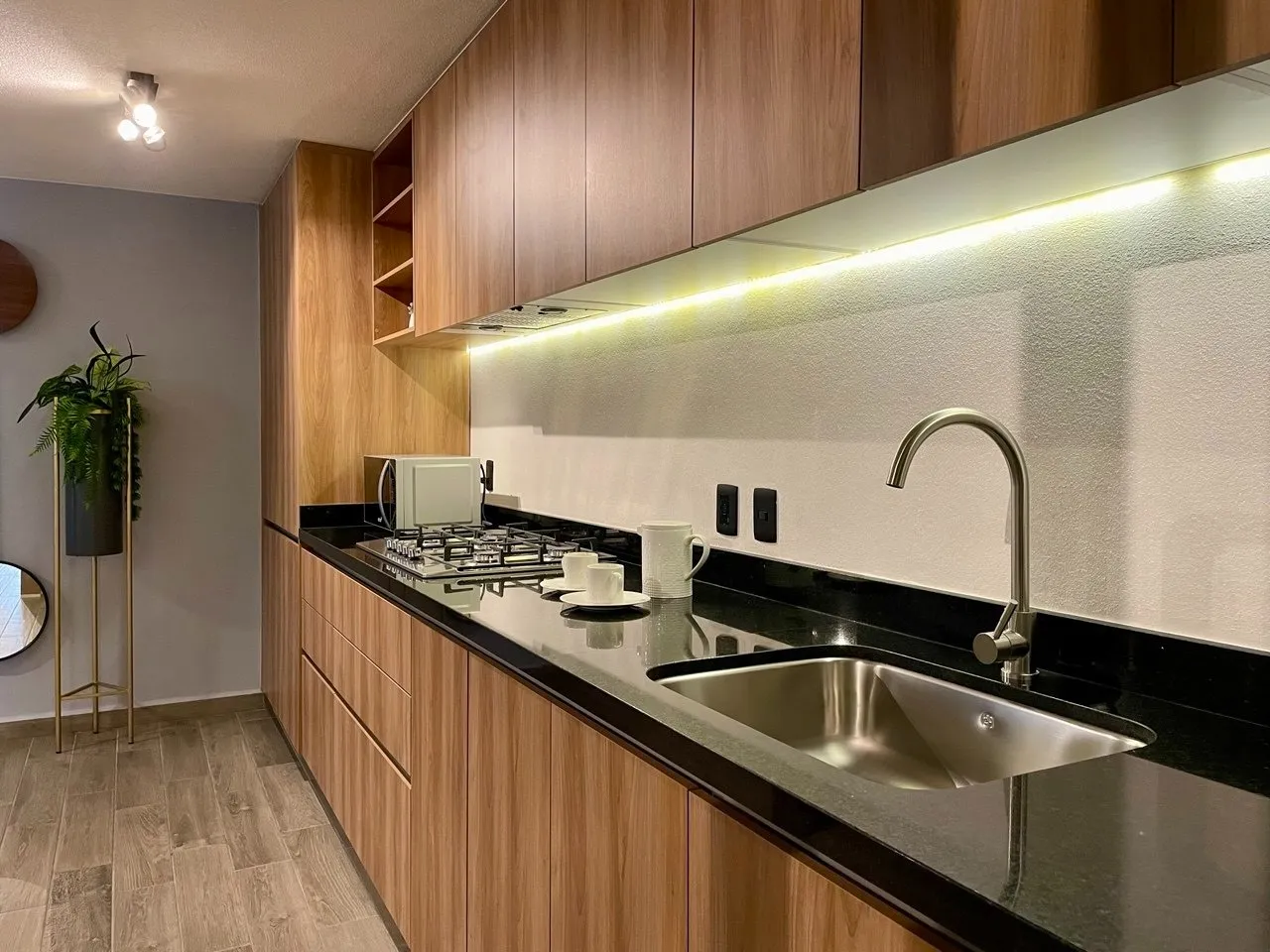 Cocina con cubierta de granito negro y gabinetes de madera